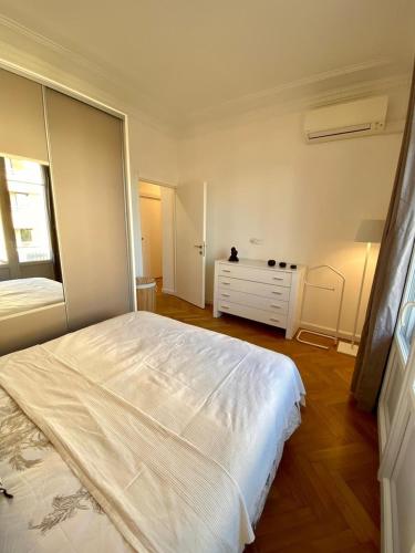 - une chambre avec un grand lit blanc et une commode dans l'établissement Bel appartement proche plage, à Antibes