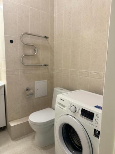 ein Badezimmer mit einer Waschmaschine und einem WC in der Unterkunft Квартира in Taldykolʼ