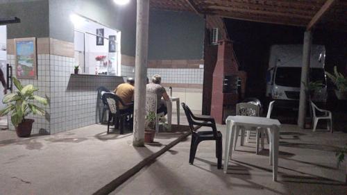 Hotel Contorno في Santa Inês: رجل يجلس على طاولة في الفناء