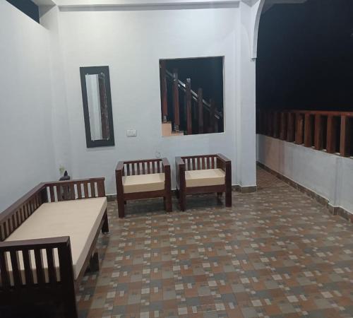 a room with three wooden benches and a mirror at Stillwater Homestay in Chikmagalūr