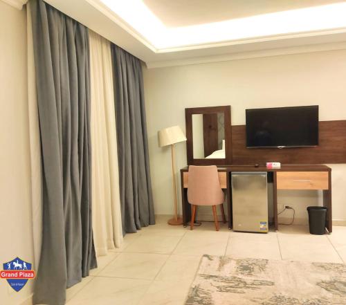 a living room with a television and a desk with a mirror at Grand Plaza Sheikh Zayed in Kafr Abū ʼumaydah