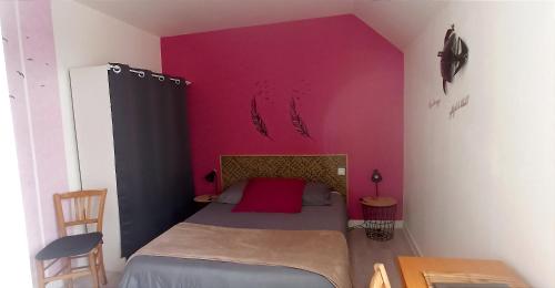 une chambre avec un lit avec un mur rose dans l'établissement LE RUN AR MOR 22, à Bas Kerhain