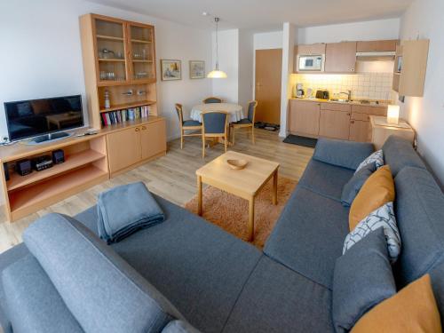 a living room with a blue couch and a kitchen at Wohnpark Stadt Hamburg - Apt. 27 in Binz