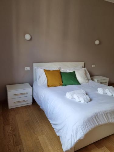 een slaapkamer met een groot wit bed en handdoeken bij Massi’s House in Milaan