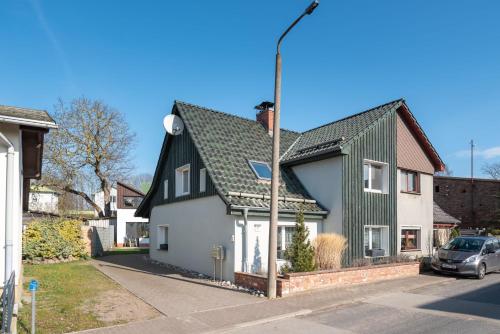 a white and black house with a green roof at Ferienwohnung Mick - Dachgeschoss in Dargen