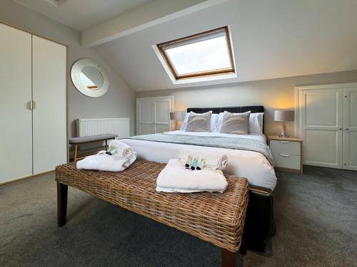 1 dormitorio con 1 cama grande y toallas en un banco en Central - Free Parking - Relocating - Business, en Harrogate