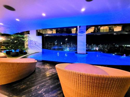 a bar with a view of a city at night at Gramercy staycaytion in Manila