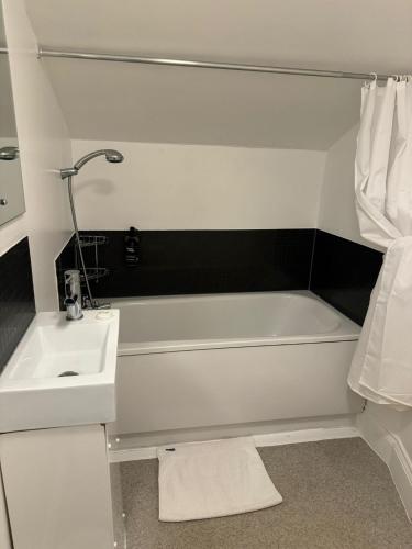 a bathroom with a white tub and a sink at Duke of Buckingham in Portsmouth