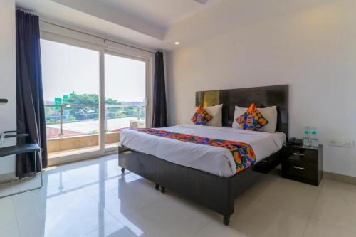 a bedroom with a large bed and a large window at TIPSYY INN 007 in Gurgaon