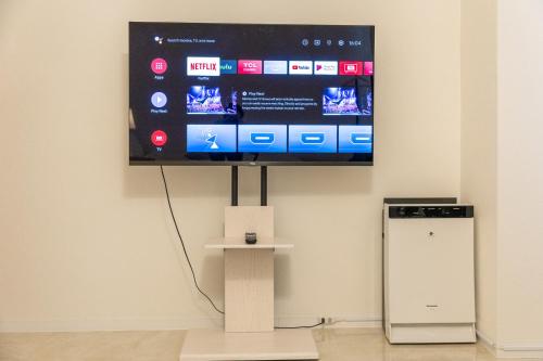 a flat screen tv hanging on a wall at Elena Premium Namba Stay in Osaka