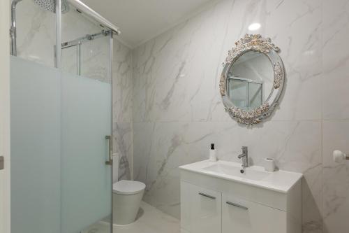 a white bathroom with a sink and a mirror at Quinta Flor de Lis, Gerês in Vieira do Minho