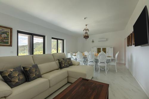 a living room with a couch and a table and chairs at Quinta Flor de Lis, Gerês in Vieira do Minho
