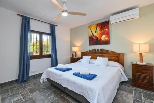 een slaapkamer met een groot bed met blauwe handdoeken bij Sonrisa in Jávea