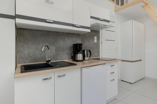 a kitchen with white cabinets and a sink at Beautiful Apartments Herberta by Rent like home in Świnoujście