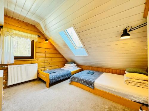 1 Schlafzimmer mit 2 Betten und einem Fenster im Dachgeschoss in der Unterkunft Chata pod Jaworem in Wisła
