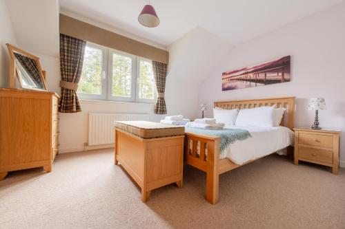 1 dormitorio con 1 cama y 2 ventanas en Abbey Holidays Loch Ness Luxury Self Catering 2 Bedroom Cottages, en Fort Augustus