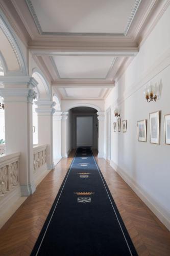 a hallway in a building with a black rug on the floor at Enjoy spring at Chateau de Monbrison, apartment for four guests in Saint-Michel