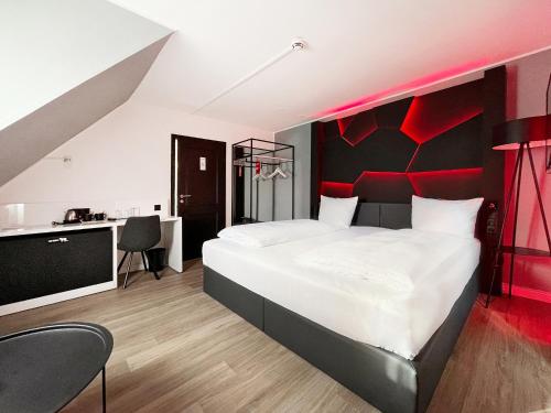 Schlafzimmer mit einem großen Bett mit einem roten Kopfteil in der Unterkunft DORMERO Hotel Xanten in Xanten