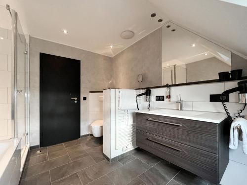 a bathroom with a sink and a toilet at DORMERO Hotel Xanten in Xanten