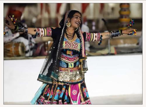 a woman performing a dance with her arms out at desert Safari Jaisalmer in Sām