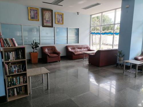 a living room with couches and a book shelf at Beachfront Cozy Studio in Ban Phe