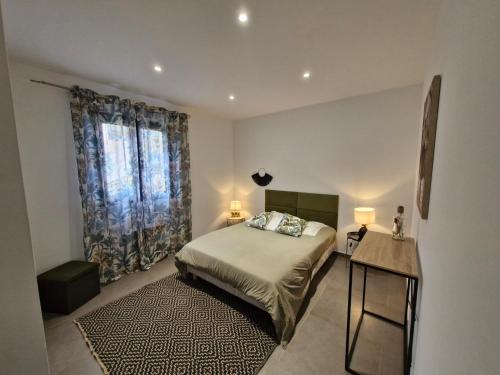 a bedroom with a bed and a table with two lamps at Casarella Alzia in Santa-Reparata-di-Balagna