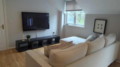 ein Wohnzimmer mit einem Sofa und einem Flachbild-TV in der Unterkunft Alexander South Shields Coast in South Shields