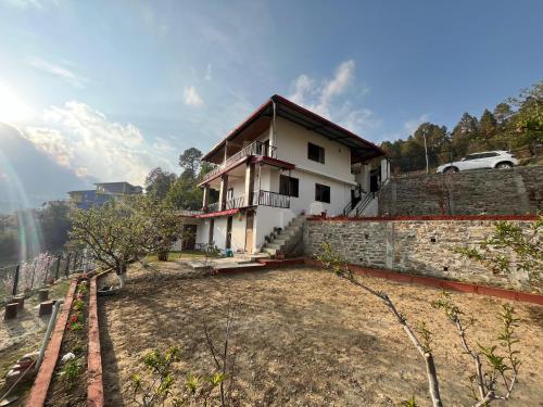 a house sitting on top of a stone wall at ValleyView Homestay in Mukteswar