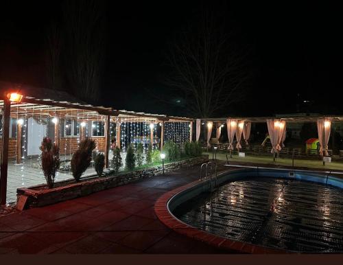 a swimming pool in front of a building at night at Brvnara Ruza Rumena in Mionica