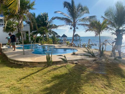a person standing next to a swimming pool next to the ocean at Casa Cenote Hotel in Tankah