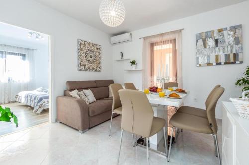 a living room with a table and a couch at Edi Funtana in Funtana