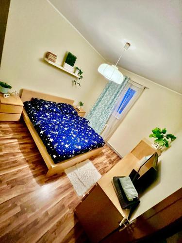 1 dormitorio con cama azul y escritorio en Boulevard rose, en Alba Iulia