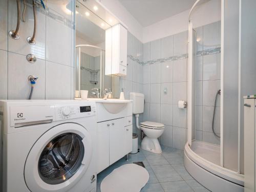 a white bathroom with a washing machine in it at Holiday home Bonaca in Rovanjska