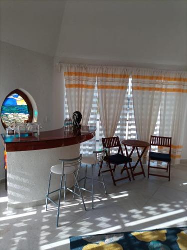 a room with a bar with chairs and a table at Casa Cenote Hotel in Tankah