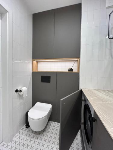 La salle de bains est pourvue de toilettes blanches et d'un lavabo. dans l'établissement Apartament Lina Koralowa samodzielne zameldowanie self check-in, à Lublin