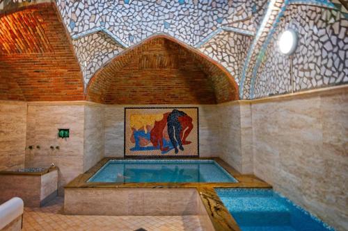 uma piscina num quarto com tecto em mosaico em Love is... em Tbilisi