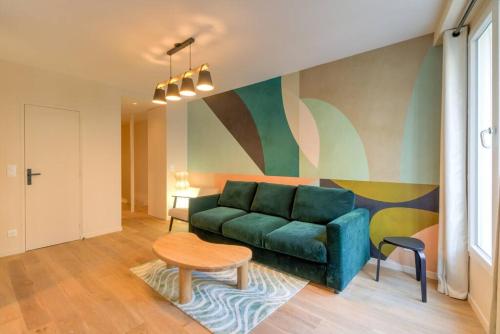 un salon avec un canapé vert et une table dans l'établissement Appart 6Pers # Père Lachaise # Voltaire # Paris 11, à Paris