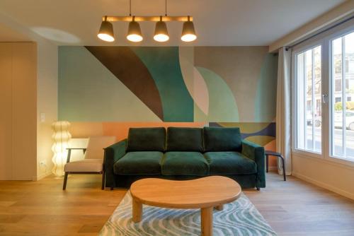 un salon avec un canapé vert et une table dans l'établissement Appart 6Pers # Père Lachaise # Voltaire # Paris 11, à Paris