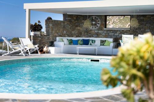 a living room with a pool and a couch and a couch at Villa Bella. Tranquil, exclusive, 4 bed, sea views in Naxos Chora