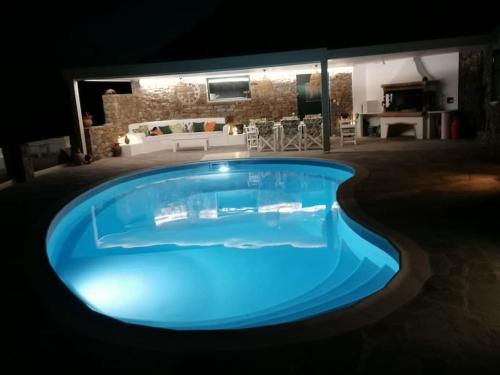 a large blue swimming pool in the middle of a house at Villa Bella. Tranquil, exclusive, 4 bed, sea views in Naxos Chora
