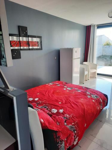 um quarto com uma cama com um cobertor vermelho em Esperanza em Cap d'Agde