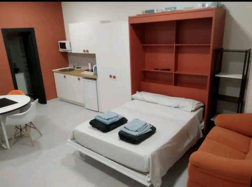 ein Schlafzimmer mit einem Bett und einem Schreibtisch sowie eine Küche in der Unterkunft Loft Puente Romano in Salamanca