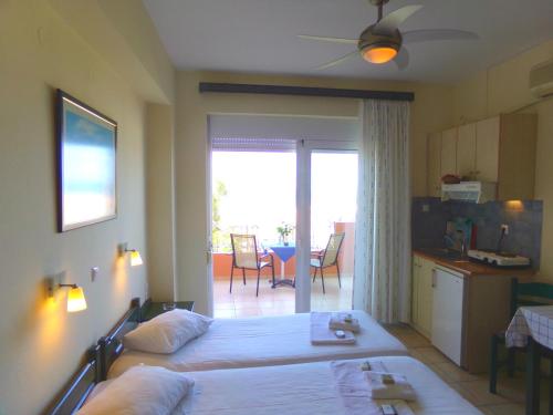 una camera con letto e una cucina con balcone di Katerina Seaside Studios a Plataniás