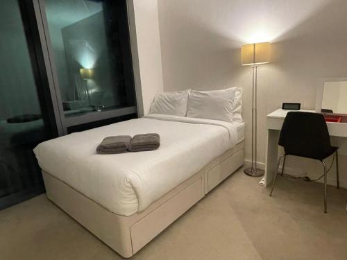 a bedroom with a bed with two towels on it at Shared Apartment in Central London in London