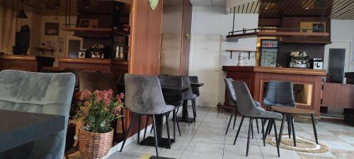 - un bar avec un bouquet de chaises dans un restaurant dans l'établissement Hotel Luxembourg, à Lourdes