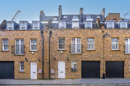 a large brick building with white doors and windows at The Shepherd Residence in London