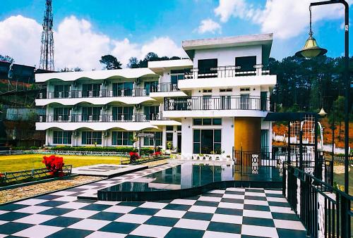 un edificio con un pavimento a scacchi di fronte ad esso di La Nicholas Lake View by Summit Hotels a Mawlyngkhung
