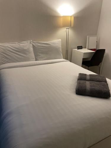 a white bed with a towel on top of it at Shared Apartment in Central London in London