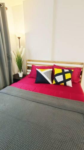 a bedroom with a red bed with colorful pillows at Cozy & Easy living Condo 65/79 in Kathu