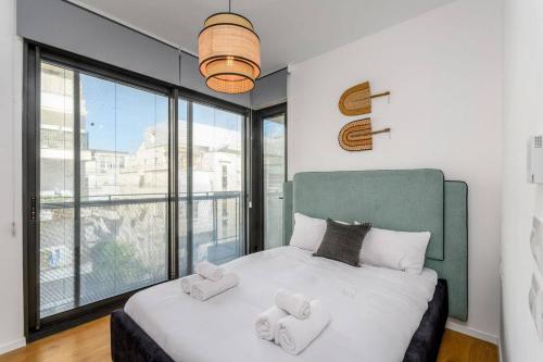 um quarto com uma cama e uma janela grande em Dandy Style from Sea U TLV em Tel Aviv